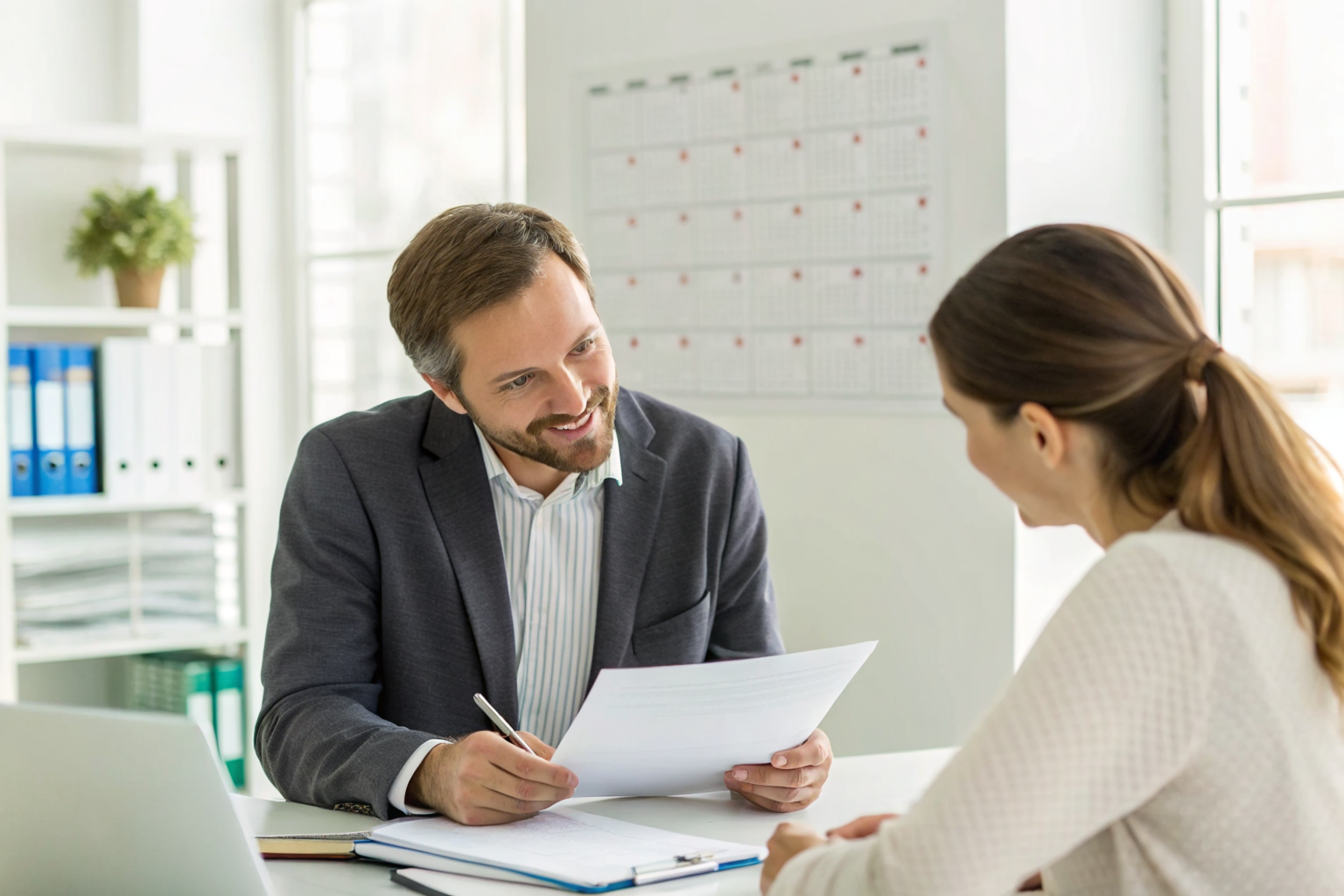 Insurance agent and client discussing policy reviews in a well-lit office.