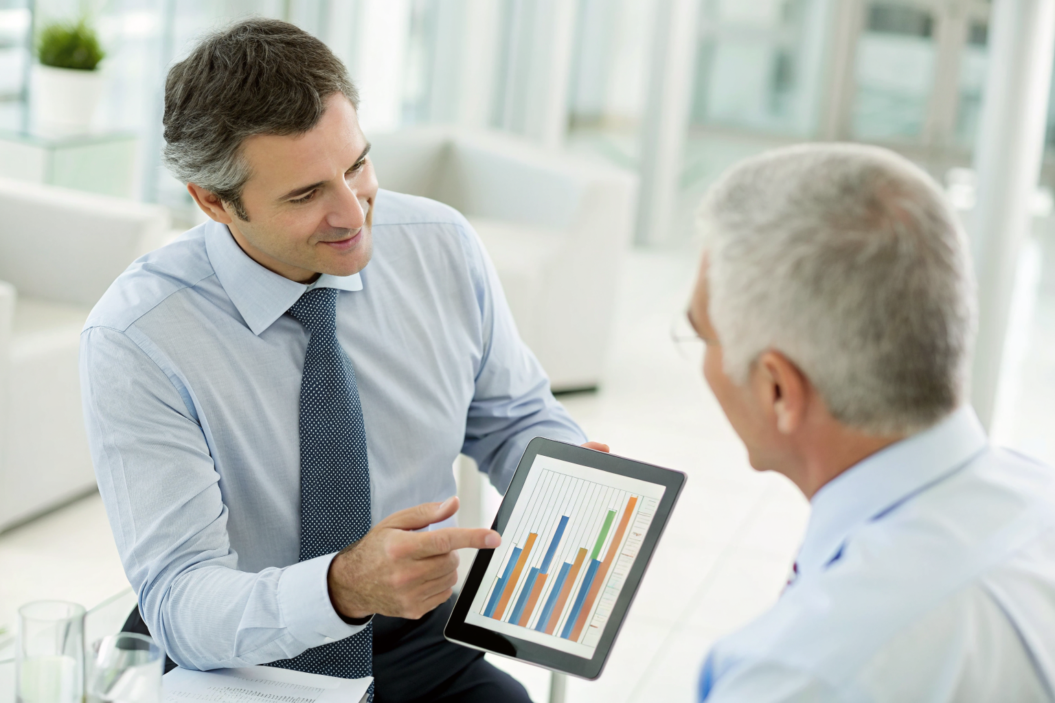 Advisor explaining Arizona liability coverage using a tablet in an office.