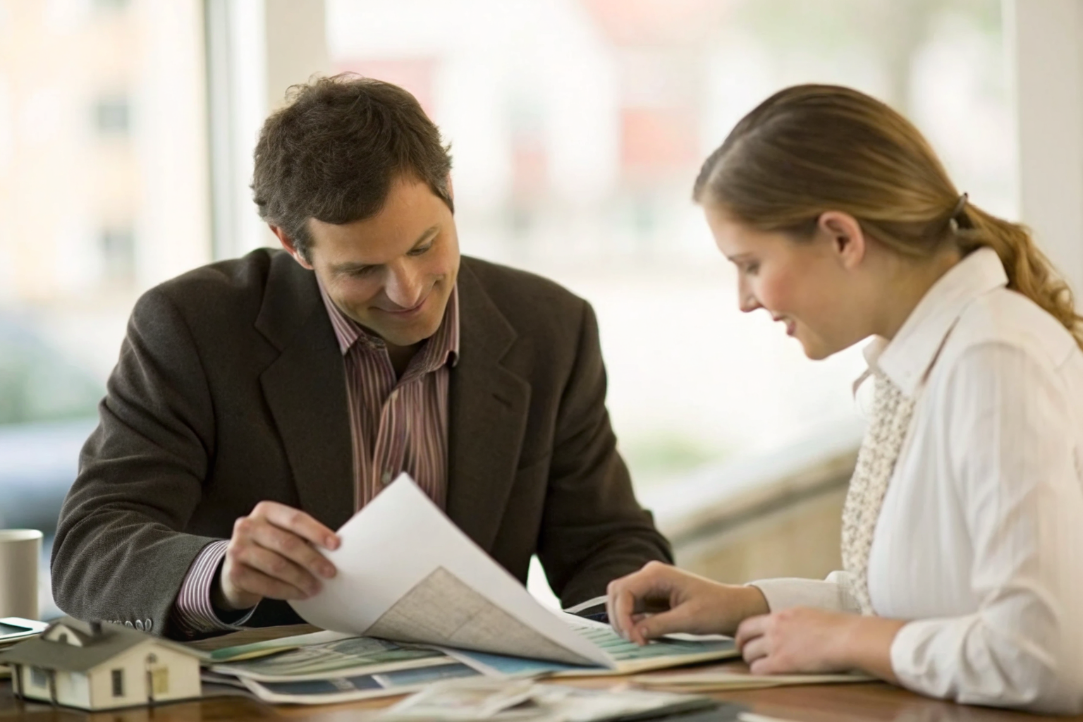 Insurance agent showing policy details to a business owner.