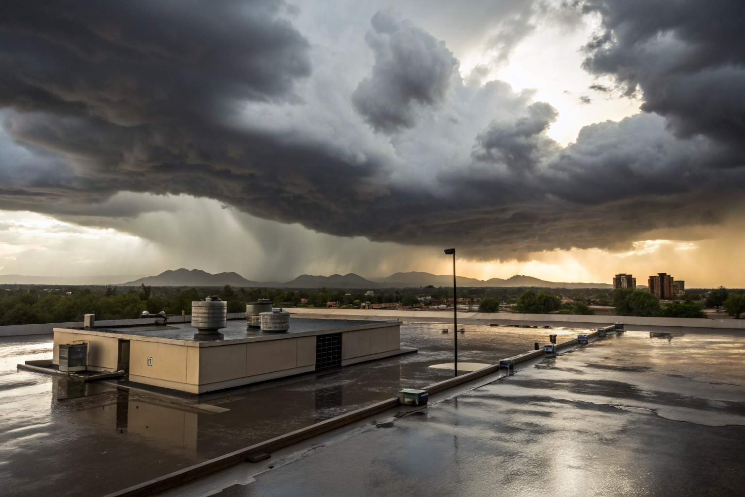 Commercial flat roof with ponding water under storm clouds in Phoenix.