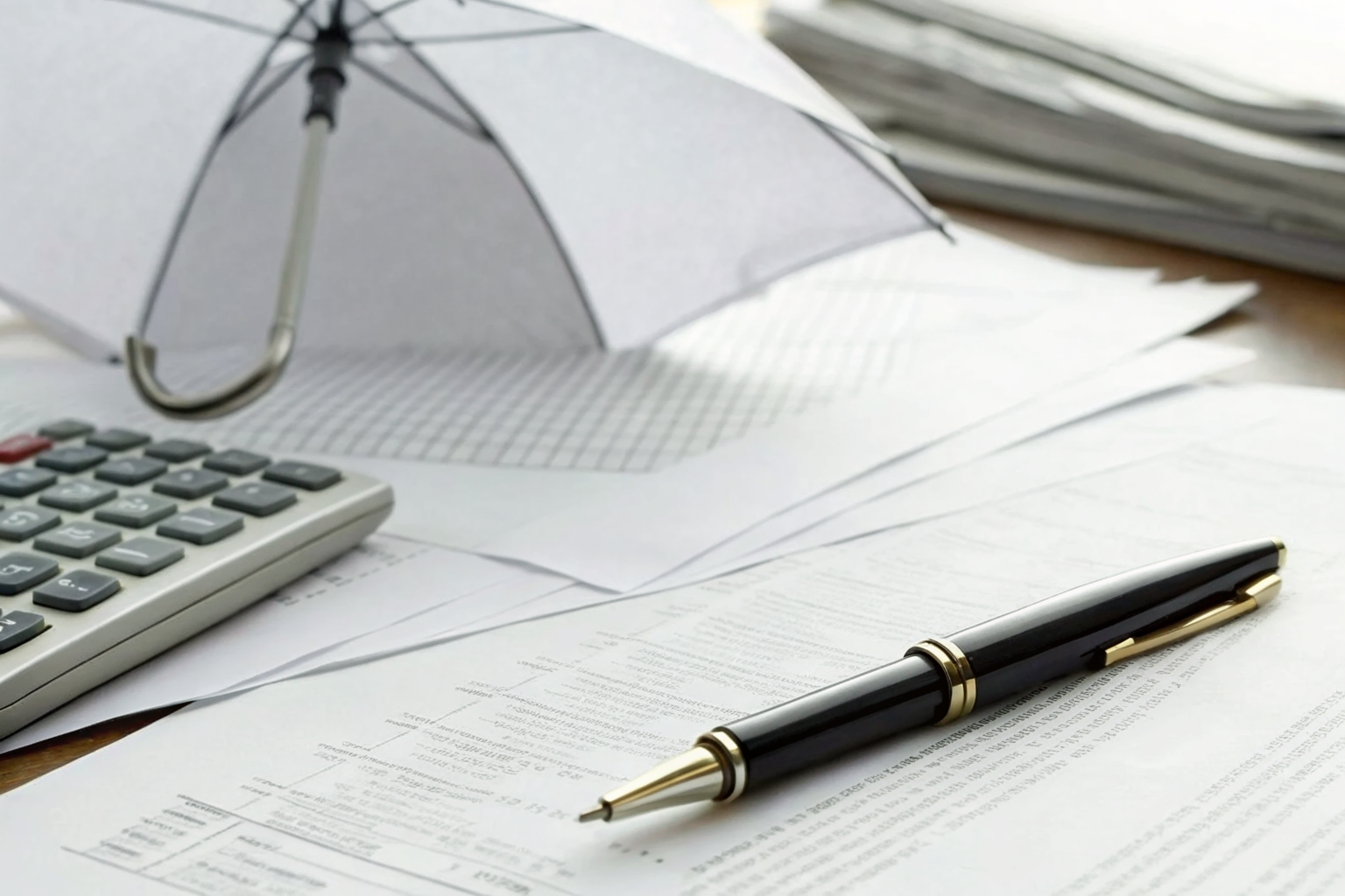 Legal documents and insurance papers on a desk with a calculator.